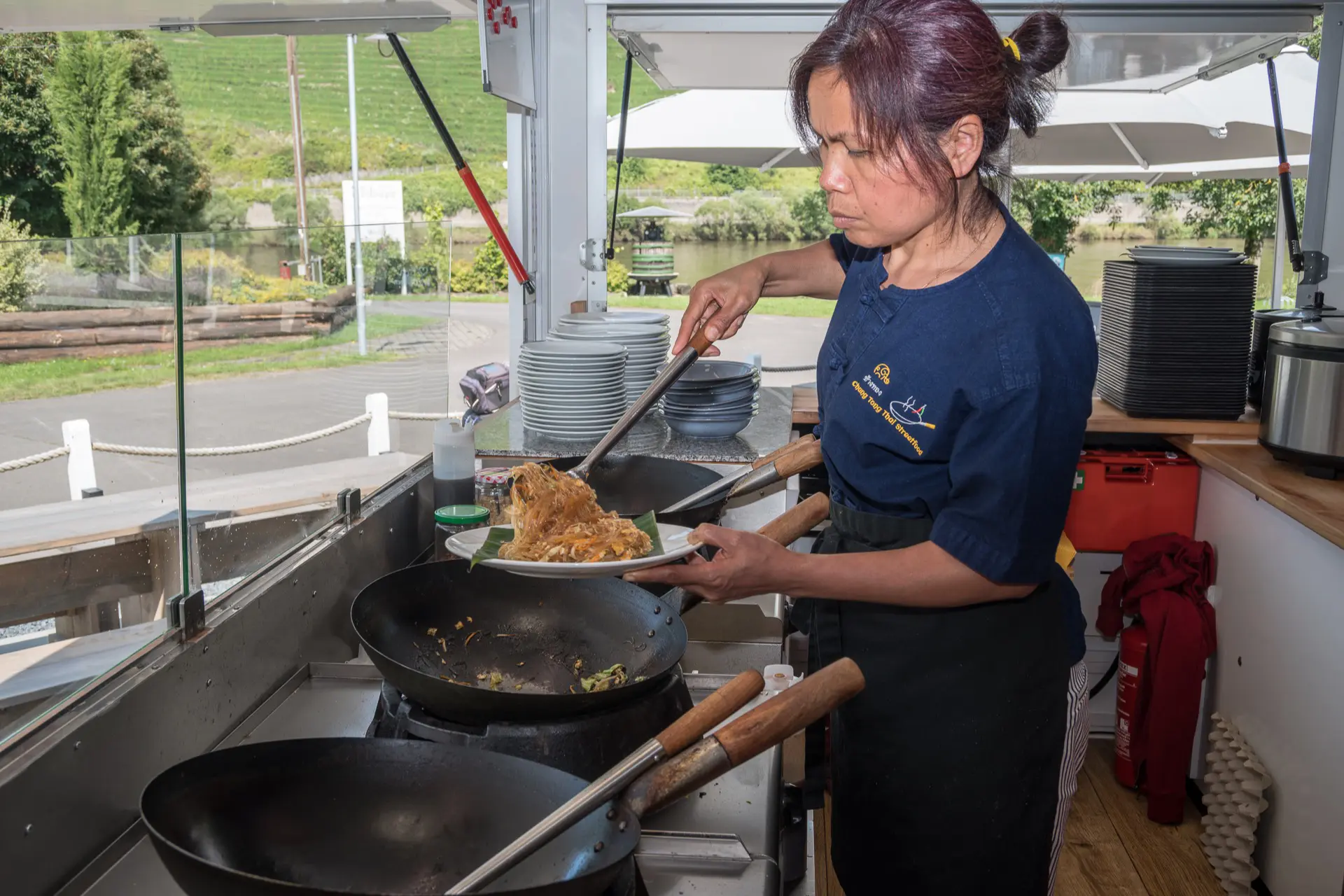 Chang Tong Köchin richtet eine Speise im Foodtruck an